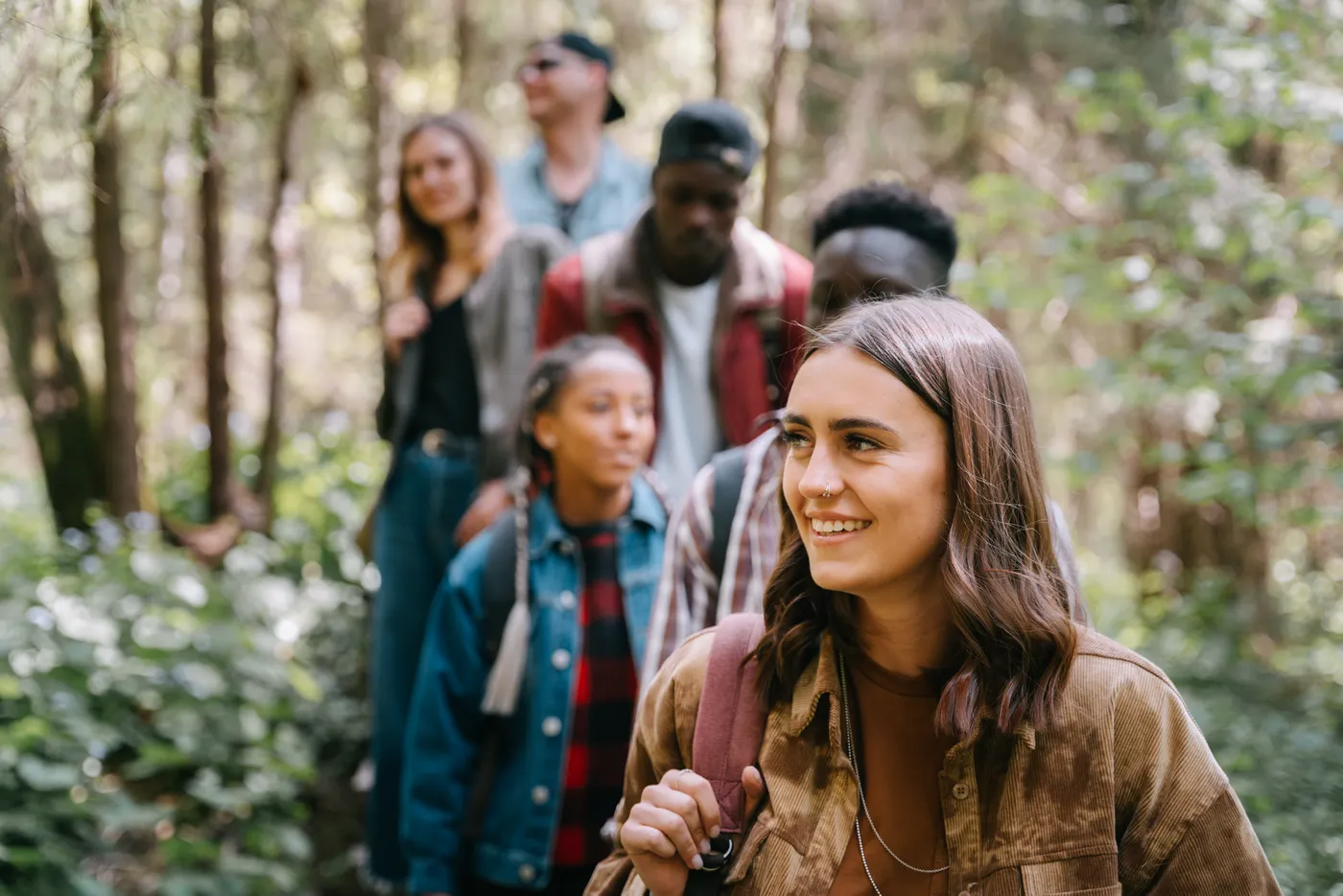 A diverse group of young people enjoying a walk in the woods